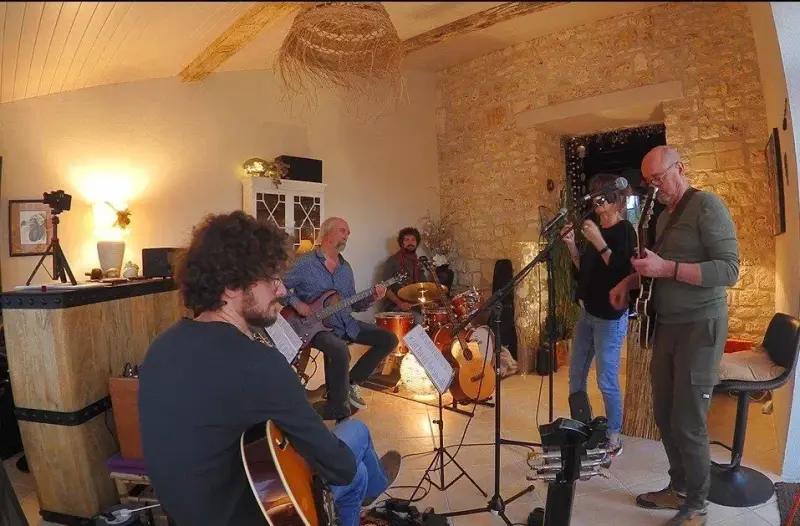 Le groupe en répétition dans un salon aux murs de pierre